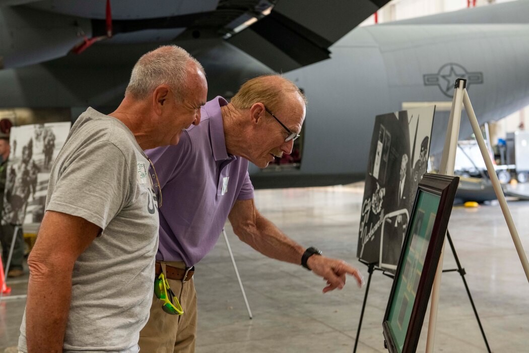Former members of the 61st Tactical Airlift Squadron view a photo display during a reunion visit