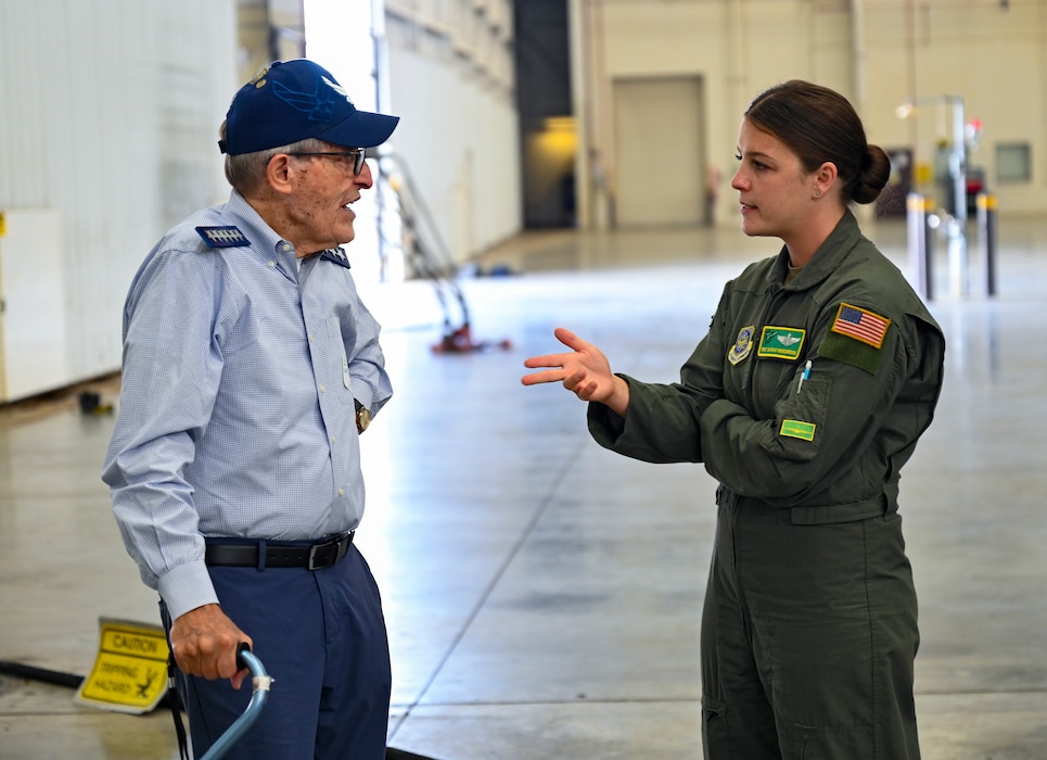 Bill London, a former member of the 61st Tactical Airlift Squadron from 1974 to 1976, left, speaks with Tech. Sgt. Sarah Henderson, 61st Airlift Squadron loadmaster, right, during a reunion visit