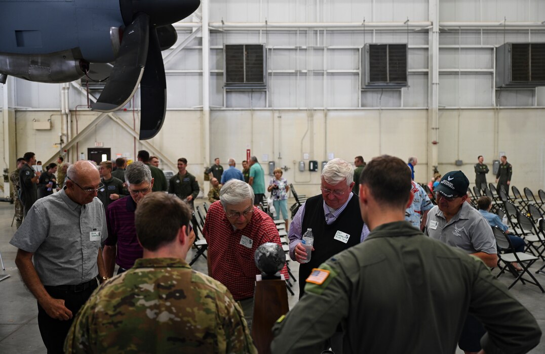 Former members of the 61st Tactical Airlift Squadron interact with Airmen assigned to the 61st Airlift Squadron during a reunion visit
