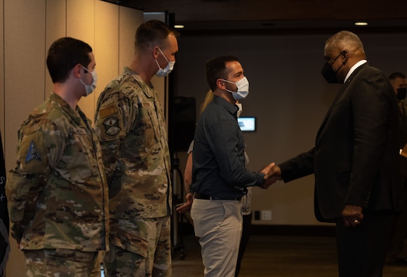 The secretary of defense shaking hands with service members