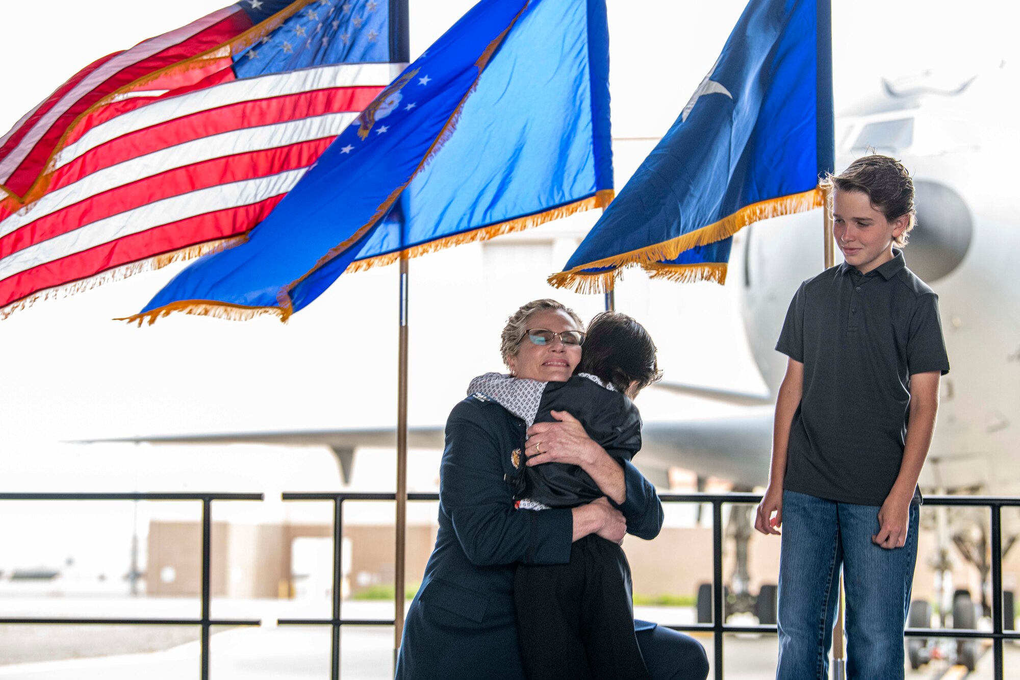 Col. Jacquelyn Marty, 349th Air Mobility Wing vice commander, shares a celebratory moment with her children during her retirement ceremony at Travis Air Force Base, Calif., June 4, 2022.  Marty is retiring after a career spanning over three decades of service. Her flying career began in 1994 at Travis Air Force Base, and came full circle as a senior leader for more than 2,600 Reserve Citizen Airmen for the past two years. (U.S. Air Force photo by Master Sgt. Jose B. Aquilizan)