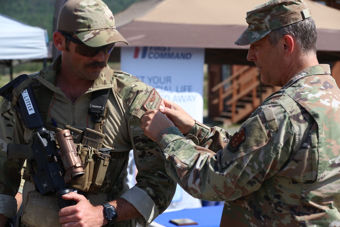 Maj. Gen. Torrence Saxe, the adjutant general of the Alaska National Guard, places the Governor's Twenty tab on the shoulder of Air National Guard Staff Sgt. Zach Little during an awards ceremony following the 2022 Adjutant General's Match held at Joint Base Elmendorf-Richardson, Alaska, on June 4, 2022. Teams of four service members competed throughout the week in a series of combat pistol and rifle marksmanship tests for their spots on the Governor’s Twenty marksmanship team. (Alaska National Guard photo by Spc. Marc Marmeto, 134th Public Affairs Detachment)