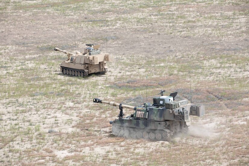 Two M109 Paladins move into firing position during exercise Western Strike22 at Orchard Combat Training Center, Idaho, June 6.