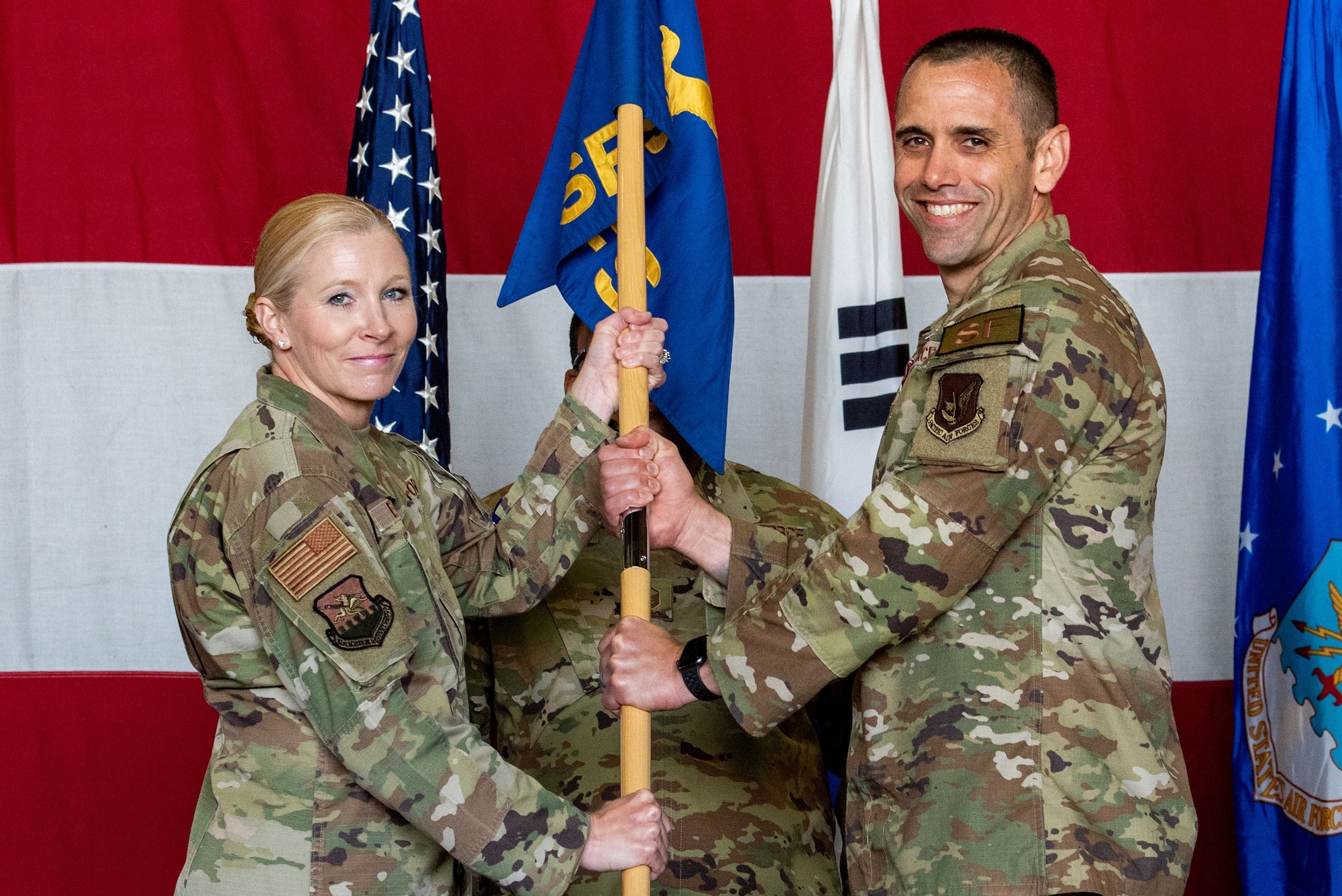 Col. Jonelle Eychner, 51st Mission Support Group commander, left, receives the guidon from Lt. Col. David Lycan, 51st Security Forces Squadron outgoing commander