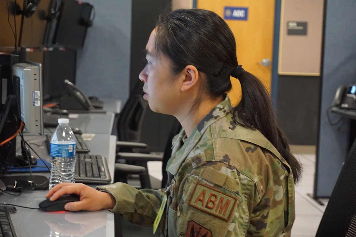 USAF Airmen sits working on a computer