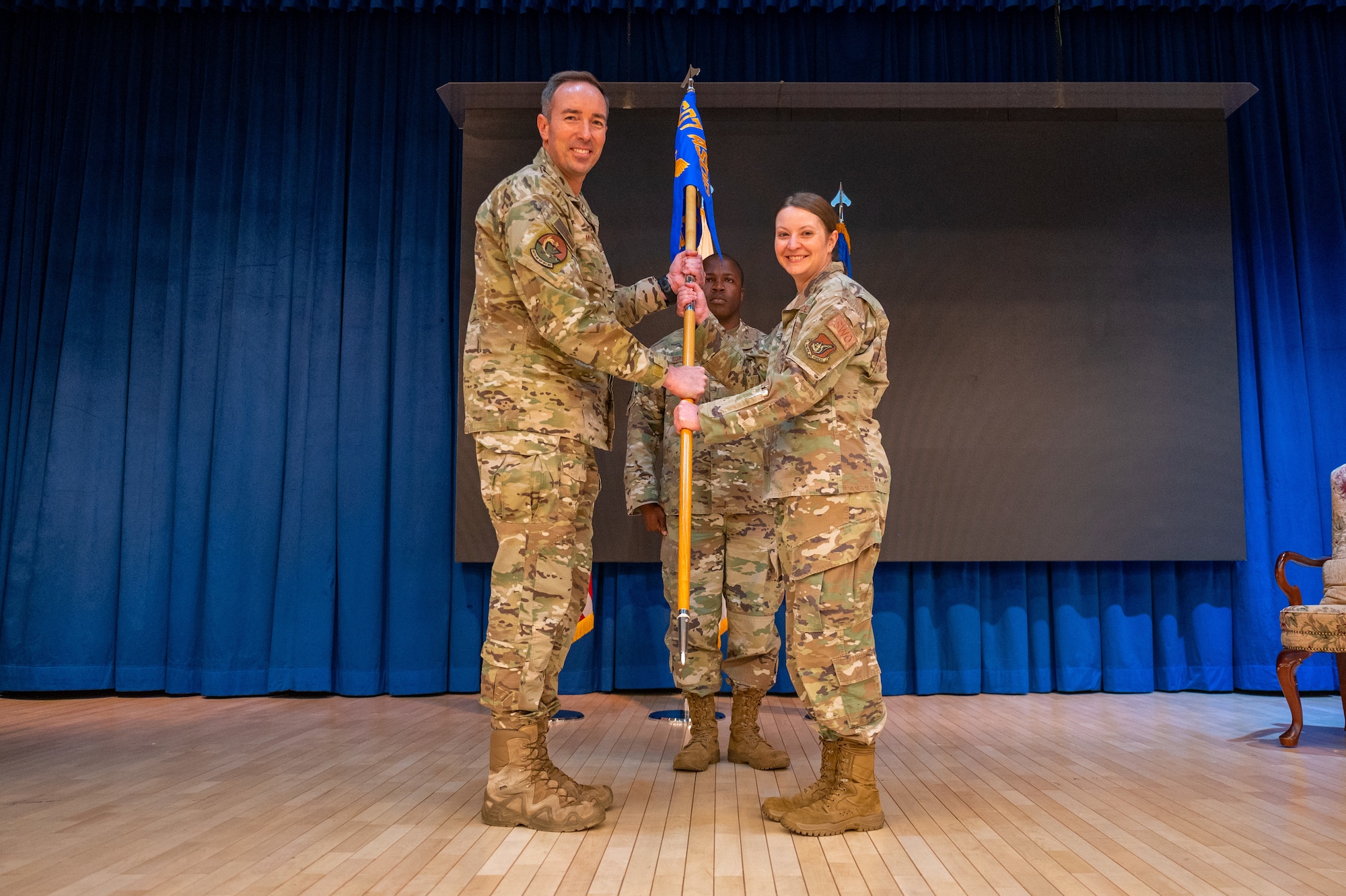 Col. Scott Morgan, 607th Air Support Operations Group commander, left, presents Lt. Col. Nessa Hock, 607th Combat Weather Squadron (CWS) commander, the guidon during the Assumption of Command ceremony