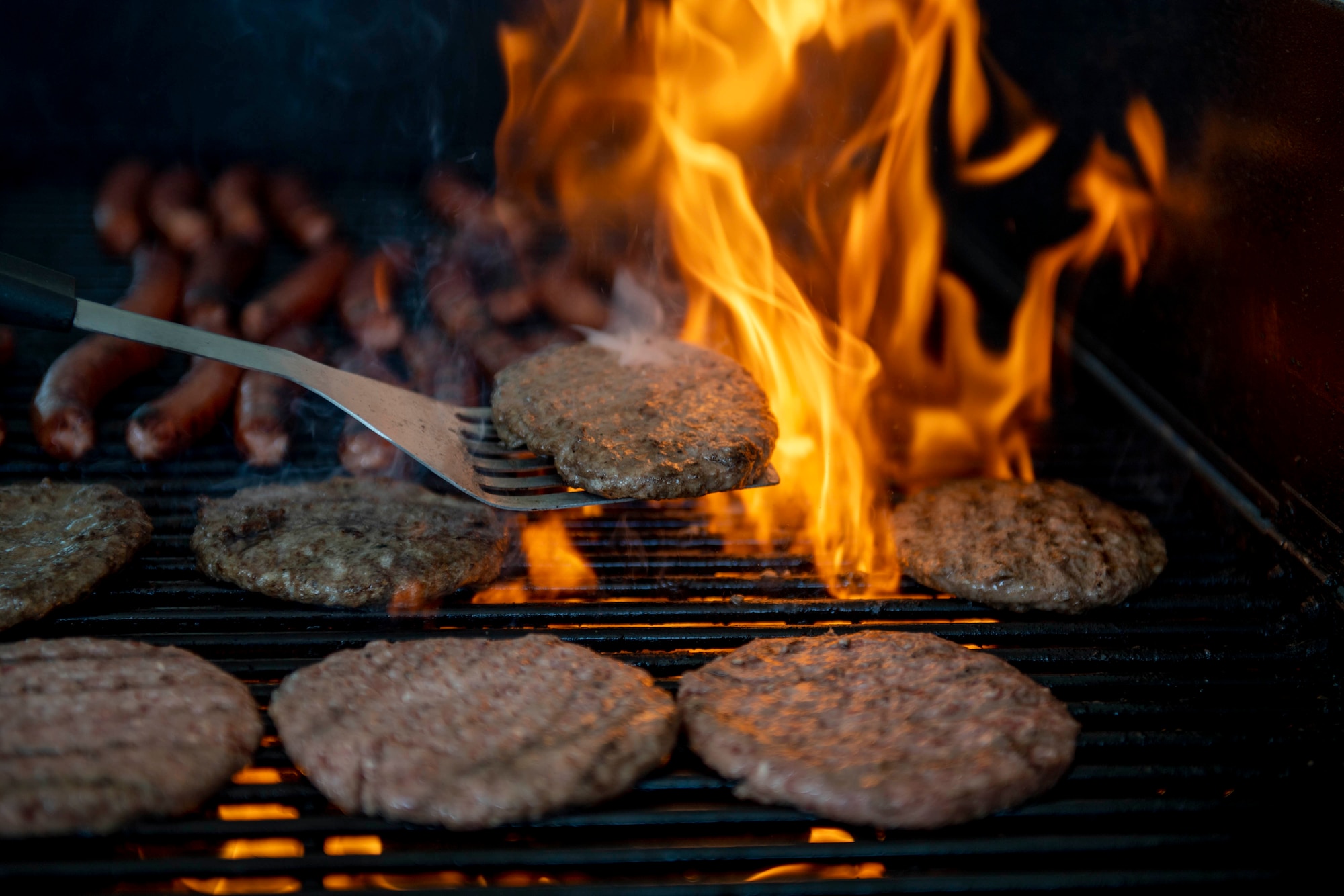 Staff Sgt. Charles Munson, 436th Civil Engineer Squadron emergency management noncommissioned officer in charge, grills hamburgers and hotdogs during the 2022 Hurricane Block Party at Dover Air Force Base, Delaware, June 2, 2022. The block party, sponsored by the 436th CES Emergency Management flight, offered attendees useful information pertaining to severe storms and hurricanes. Additionally, attendees toured several booths set up by local organizations and base units, offering free gifts and information. (U.S. Air Force photo by Tech. Sgt. J.D. Strong II)