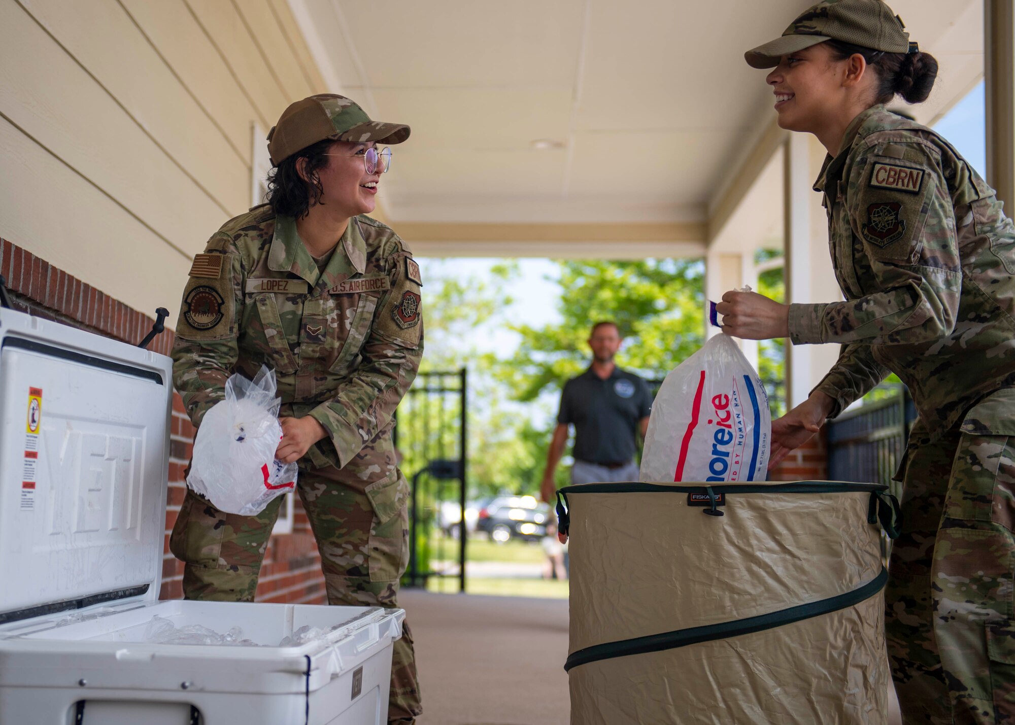 Airman 1st Class Thaliah Lopez, left, 436th Civil Engineer Squadron emergency management apprentice, and Senior Airman Ashley Nicholas, 436th CES emergency management journeyman, fill a cooler with ice during the 2022 Hurricane Block Party at Dover Air Force Base, Delaware, June 2, 2022. The block party, sponsored by the 436th CES Emergency Management flight, offered attendees useful information pertaining to severe storms and hurricanes. Additionally, attendees toured several booths set up by local organizations and base units, offering free gifts and information. (U.S. Air Force photo by Tech. Sgt. J.D. Strong II)
