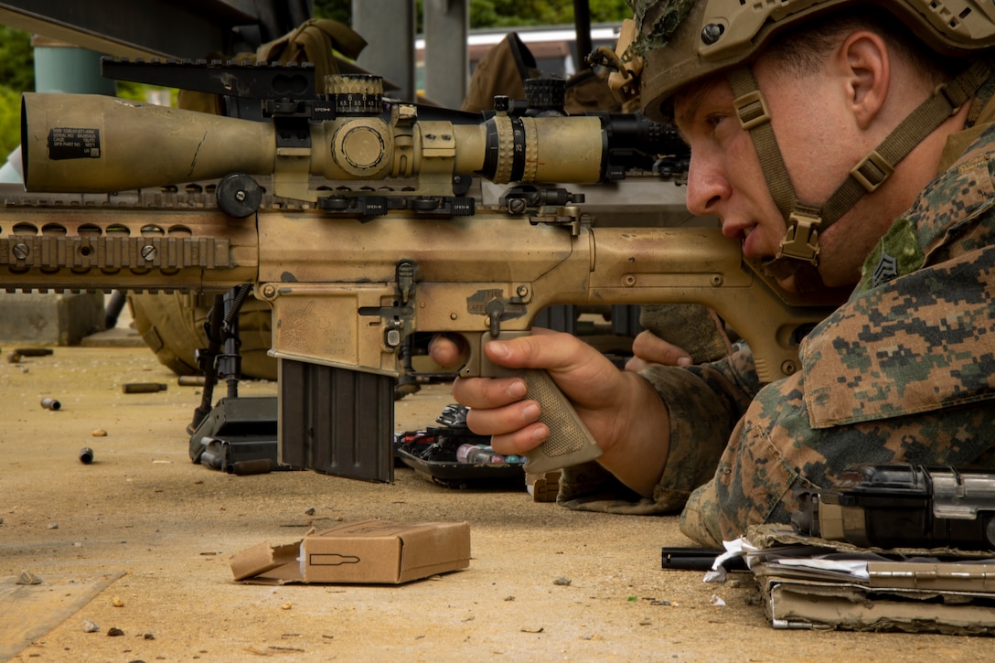 U.S. Marine Corps Sgt. Trevor Hancock, a team leader with 2nd Battalion, 2nd Marine Regiment, 2nd Marine Division, fires his rifle during an Urban Sniper Course on Camp Hansen, Okinawa, Japan, May 25, 2022. The Urban Sniper Course was led by Marines with the Expeditionary Operations Training Group, III Marine Expeditionary Force, to enhance sniper skills in urban environments through precision fire, engaging targets through glass, urban tactical movement, marksmanship during the day and the night, planning, and stalking in urban terrain.