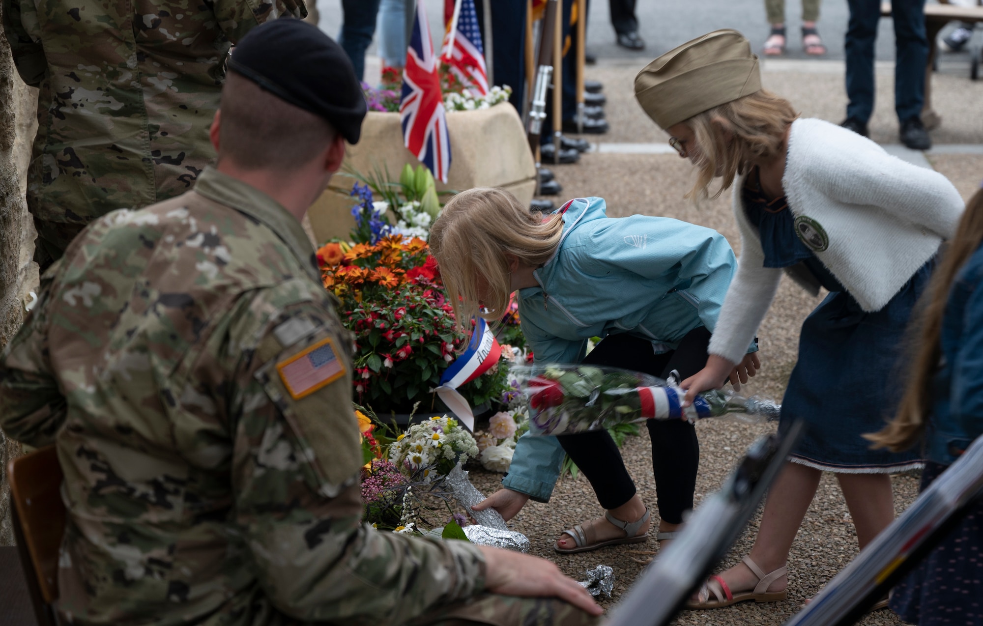 Children place flowers on a memorial during a D-Day ceremony at Negreville, France,  June 3, 2022. Negreville hosted their 24th annual D-Day memorial service as a way to thank those who fought and died to free them from occupation during World War II. (U.S. Air Force photo by Senior Airman Thomas Karol)