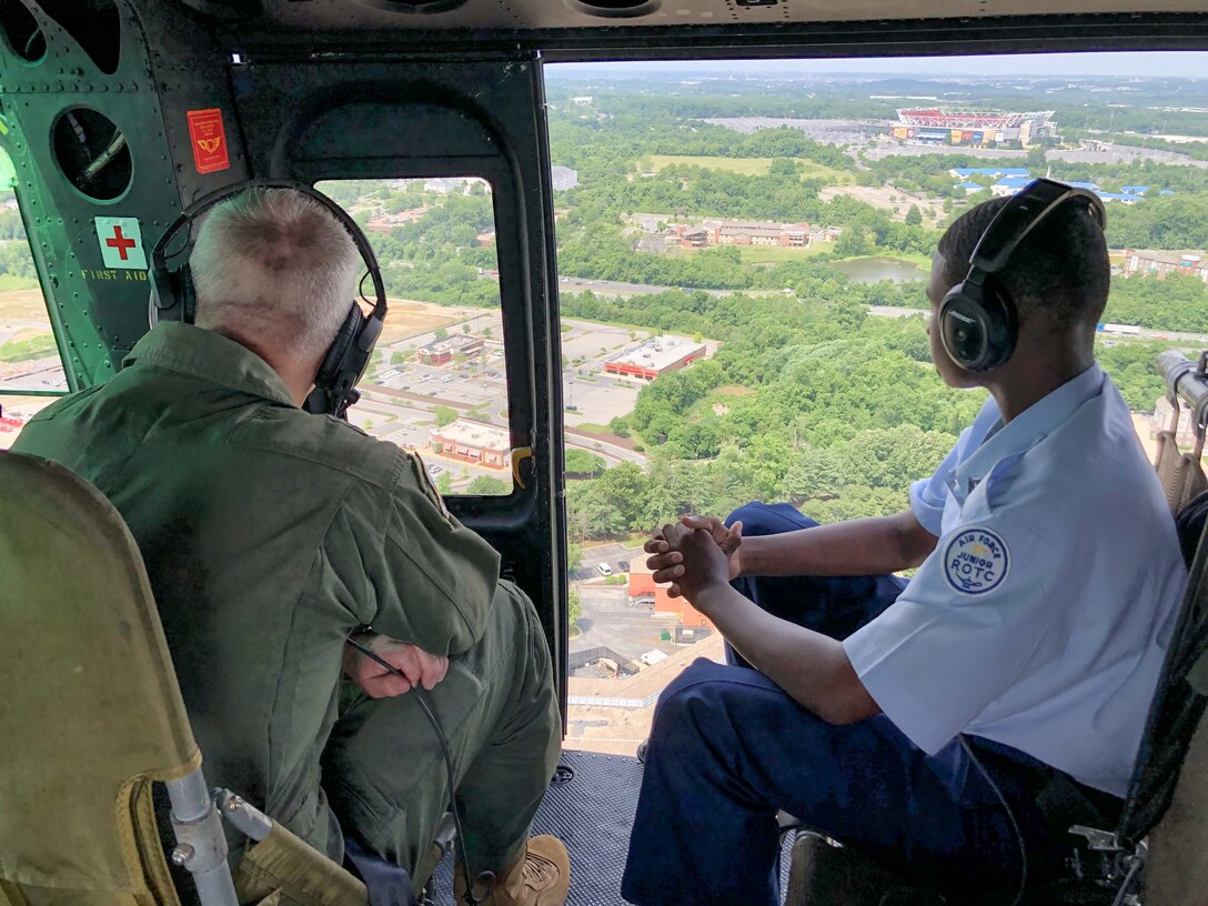 Two people look out helicopter door