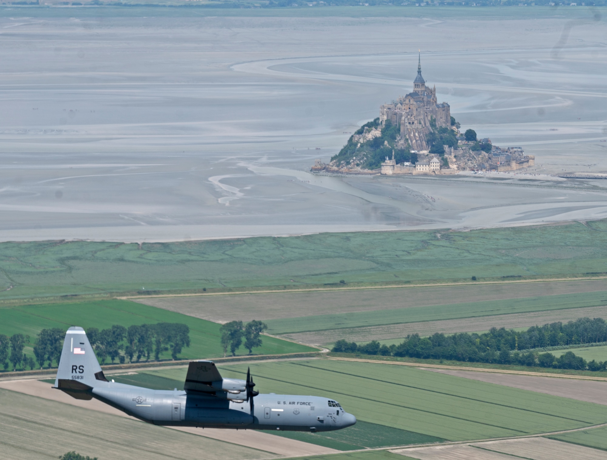 A C-130J out of Ramstein Air Base, Germany piloted by Brig. Gen. Josh Olson, 86th Airlift Wing commander, flies past Mont Saint-Michel, France, June 4, 2022. Olson came to Normandy to participate in events as well as train with the 37th Airlift Squadron by joining them in low-level flight training. (U.S. Air Force photo by Senior Airman Thomas Karol)