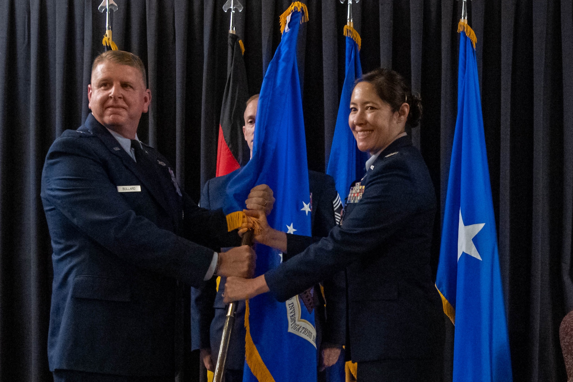 Airmen hold a flag.