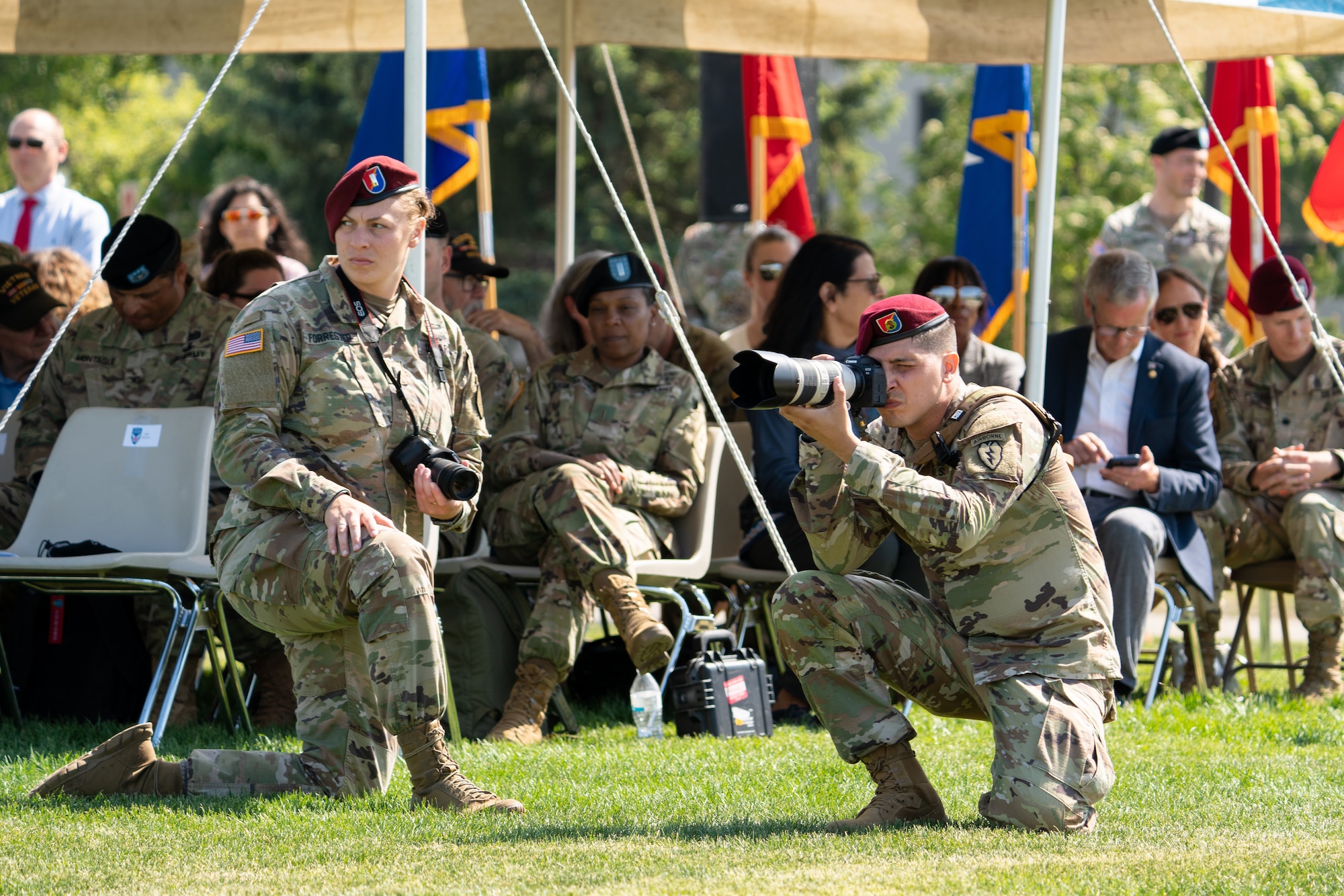 U.S. Army Soldiers take photos while documenting a ceremony