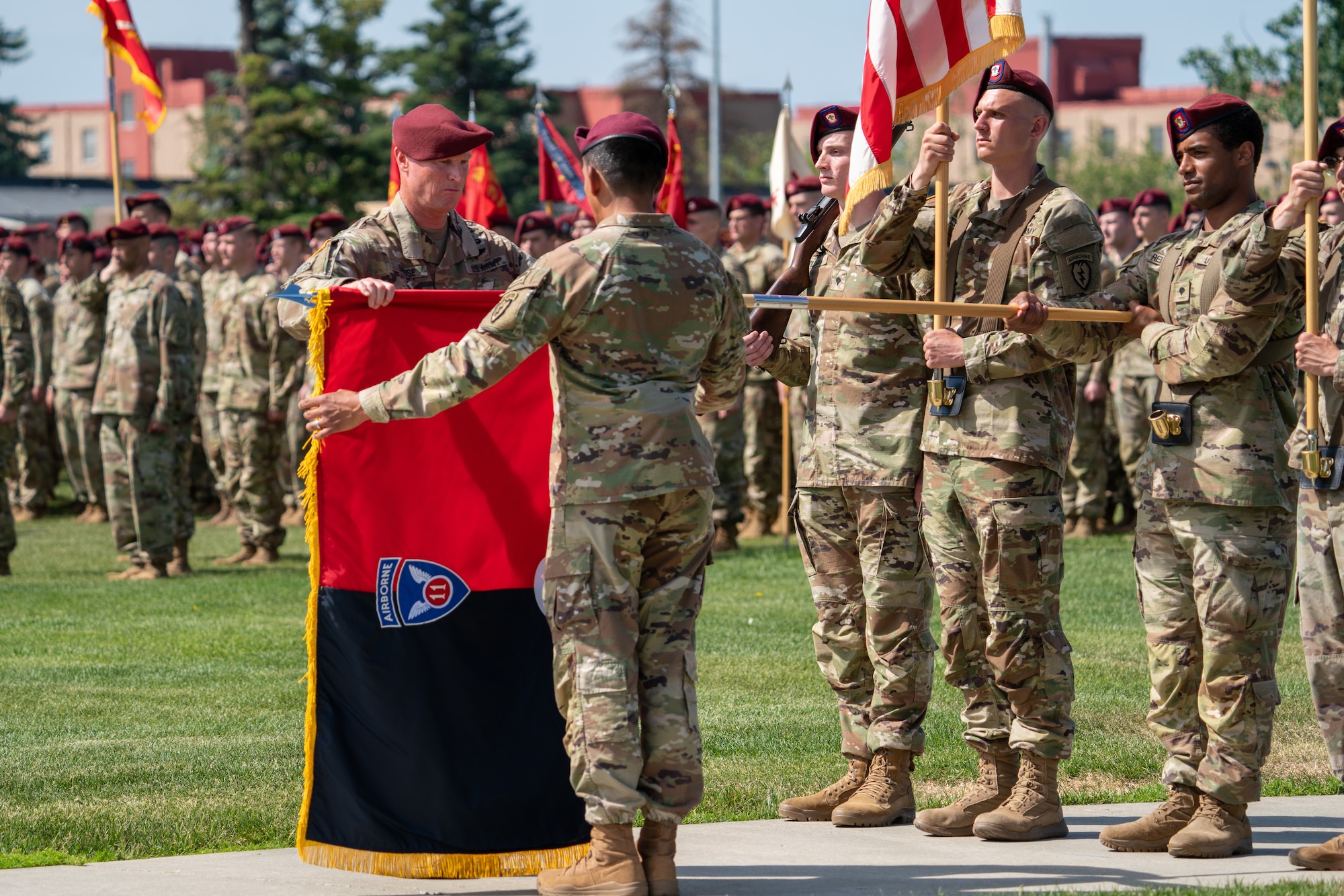 The 11th Airborne colors are uncased by two Soldiers during a ceremony