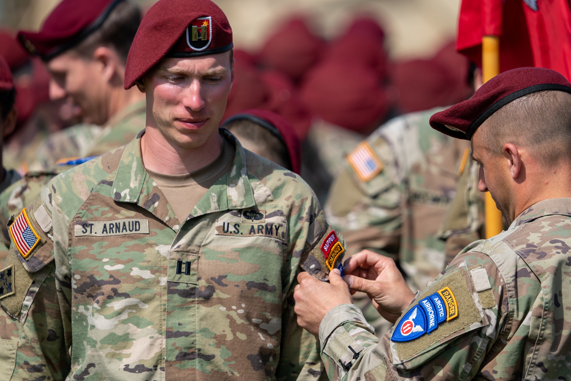 A Soldier has a new patch placed on his shoulder during a ceremony