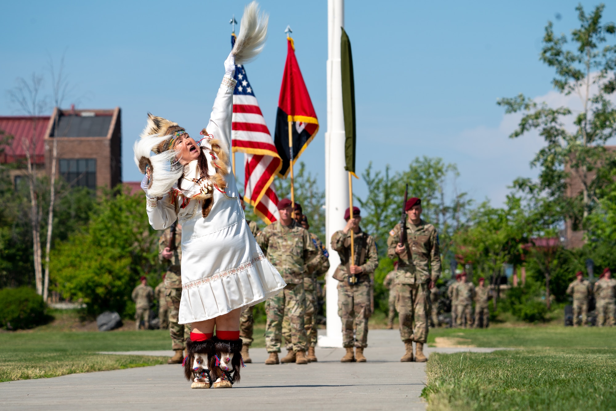 A woman in traditional Native attire performs a ceremonial dance