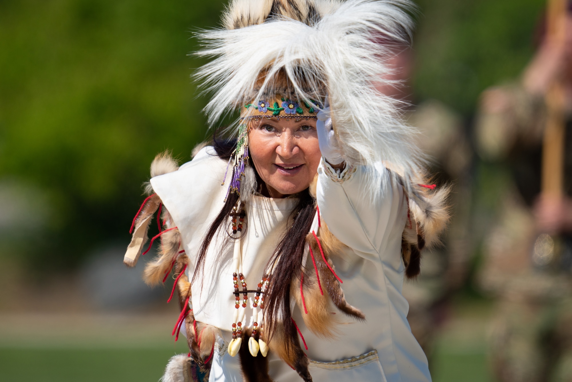 A woman in traditional Native attire performs a ceremonial dance