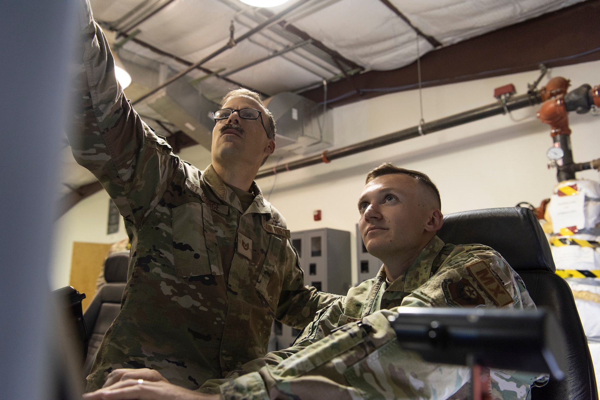 U.S. Air Force Tech. Sgt. Keith St. George, 12th Aircraft Maintenance Unit, 727th Special Operations Aircraft Maintenance Squadron MQ-9 Reaper remotely piloted aircraft ground control station (GCS) section non-commissioned officer in charge, and Staff Sgt. Gregory Stoquert, 12 AMU, 727 SOAMXS MQ-9 GCS maintenance journeyman, review system procedures for aircraft take off and landing at Cannon Air Force Base, New Mexico, May 6, 2022. The 12 AMU GCS specialists consist of traditional communications squadron Airmen integrated into aircraft maintenance, leveraging multi-domain skillsets in support of agile combat employment utilized by MQ-9 global operations. (U.S. Air Force photo by Airman 1st Class Cassidy Thomas)