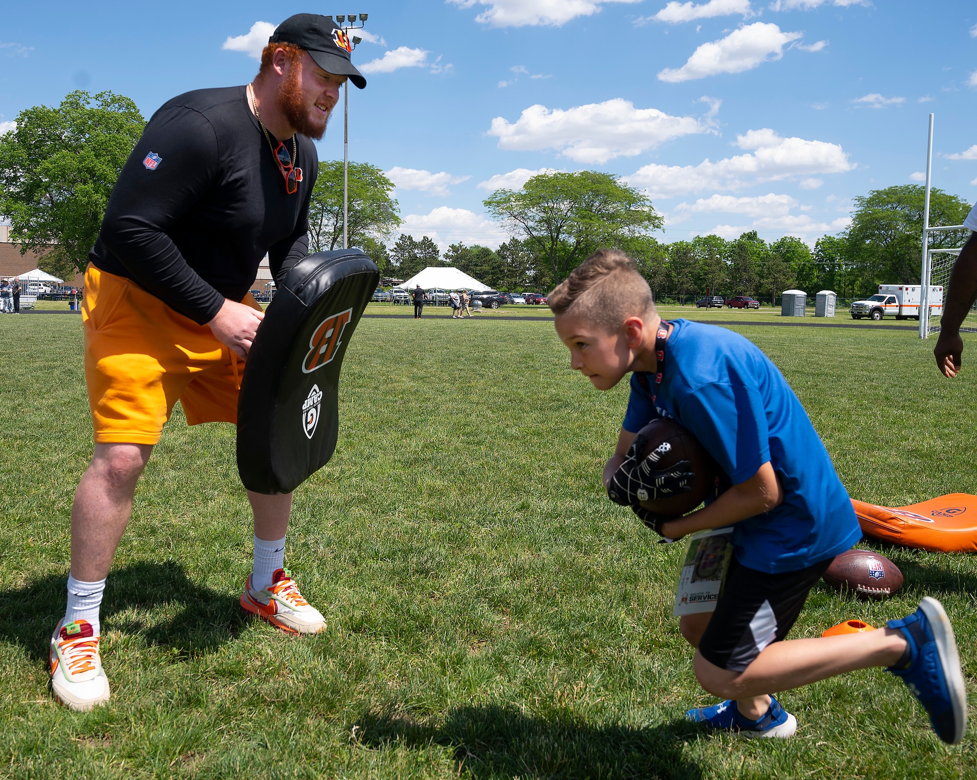 Cincinnati Bengal guard Desmond Noel
works with a participant in the
USO-sponsored Bengals’ skill clinic June 3,
2022, at Wright-Patterson Air Force Base,
Ohio. A group of Bengal rookies had lunch
with Airmen, toured the base and took part
in the skill clinic that had 99 Wright-Patt
children enrolled. (U.S. Air Force photo by
R.J. Oriez)