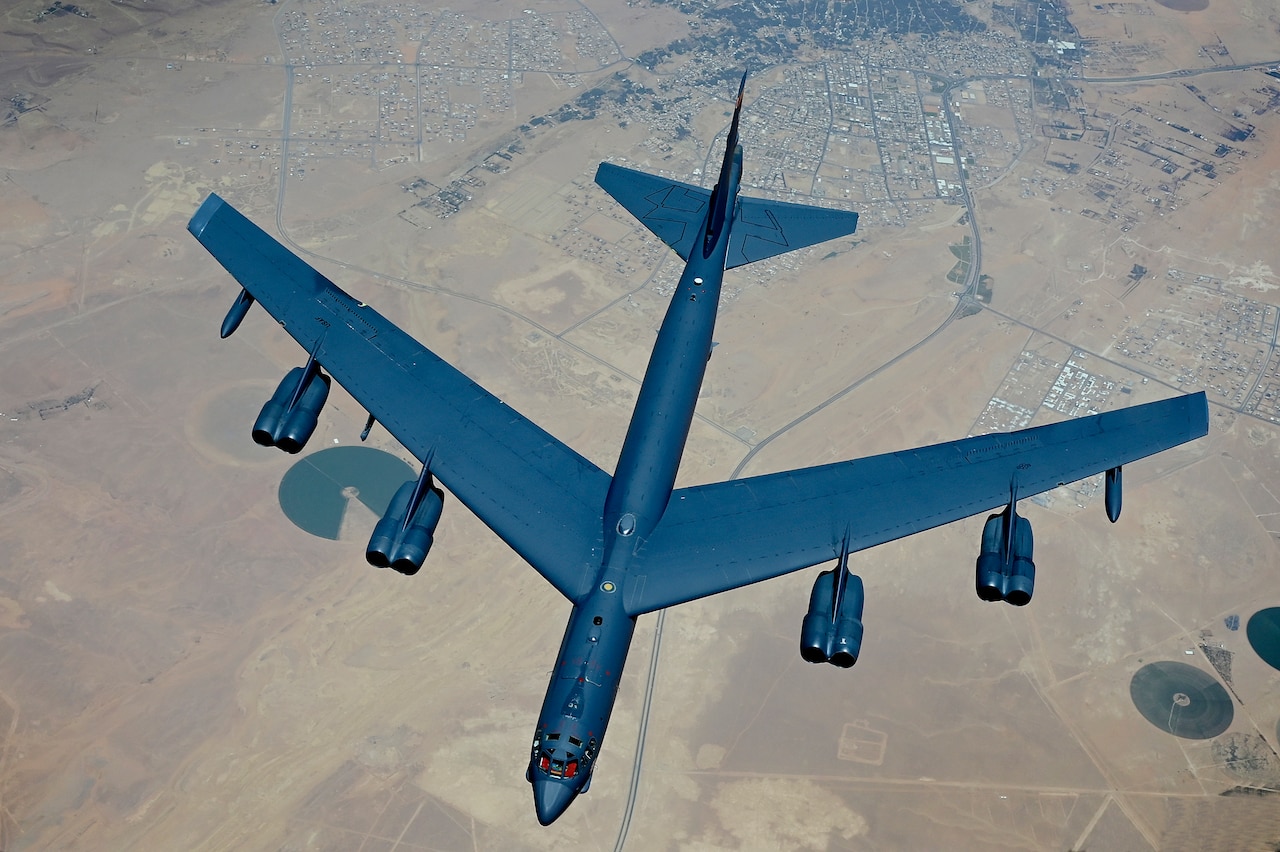 An airplane flies over a desert region.
