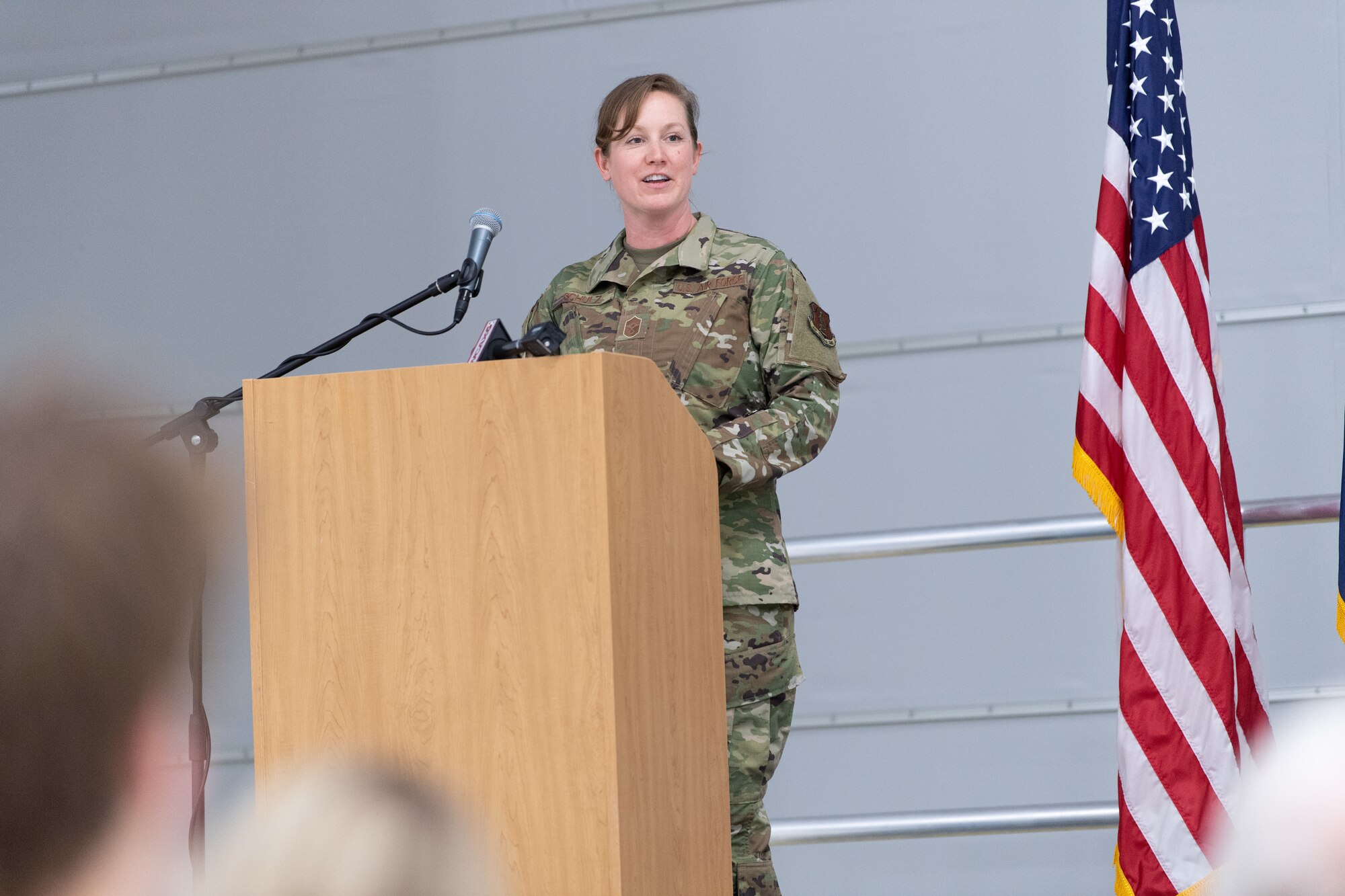 A photo of Chief Master Sgt. Adrianne Schulz, the incoming command chief for the 158th Fighter Wing, address the crowd for the first time as the new command chief at the command chief master sergeant assumption of authority ceremony at the Vermont Air National Guard Base, South Burlington, Vermont, June 4, 2022. Schulz is the first female command chief in the seven decade history of the Vermont Air National Guard. (U.S. Air National Guard photo by Master Sgt. Ryan Campbell)