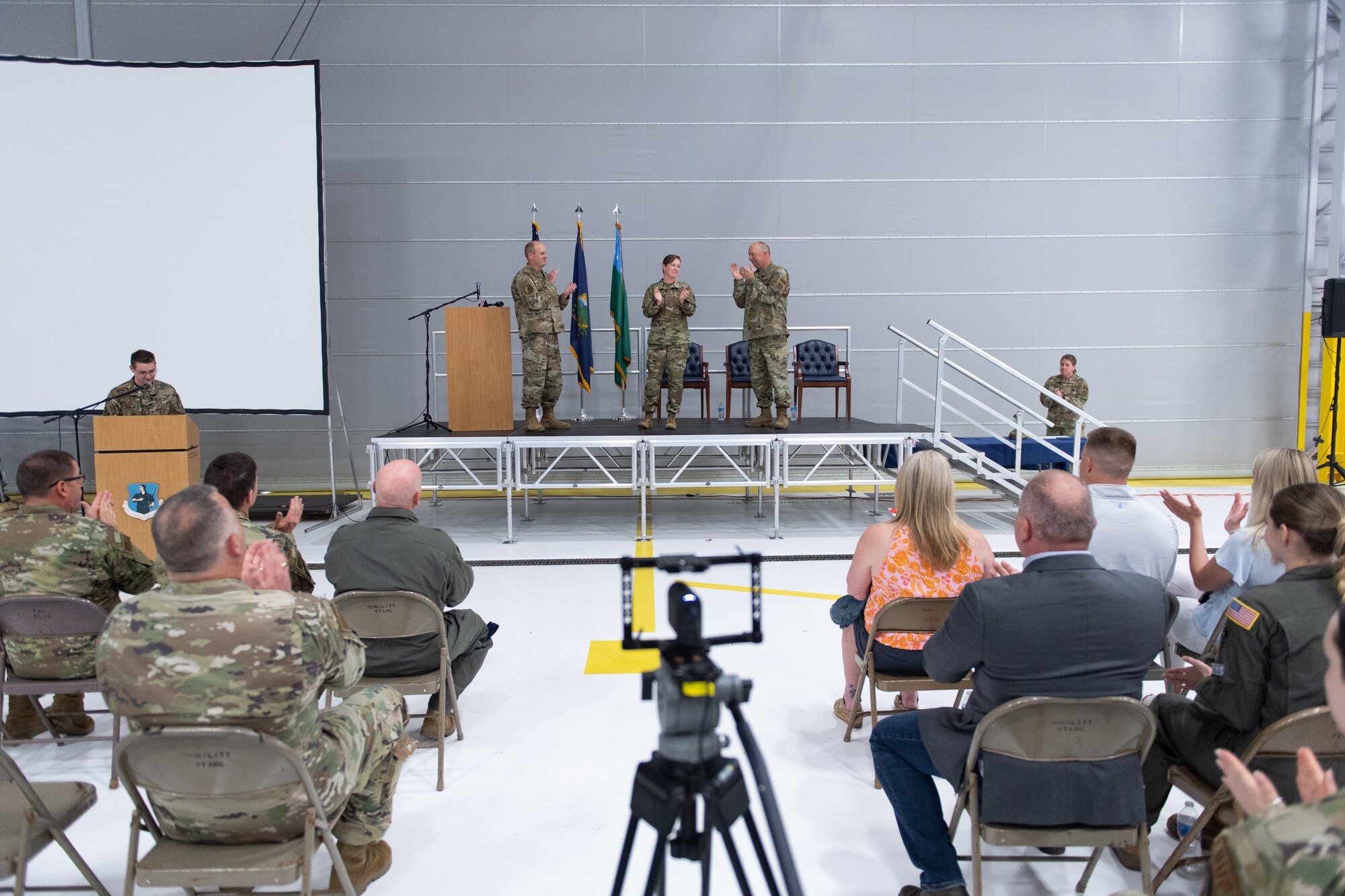 A photo of Chief Master Sgt. Adrianne Schulz, the incoming command chief for the 158th Fighter Wing, is honored as the new command chief by Col. David Shevchik, commander of the 158th Fighter Wing, Chief Master Sgt. Jeffrey Stebbins, the outgoing command chief for the 158th Fighter Wing, and from Airmen, family, and friends during the command chief master sergeant assumption of authority ceremony at the Vermont Air National Guard Base, South Burlington, Vermont, June 4, 2022. Schulz is the first female command chief in the seven decade history of the Vermont Air National Guard. (U.S. Air National Guard photo by Master Sgt. Ryan Campbell)