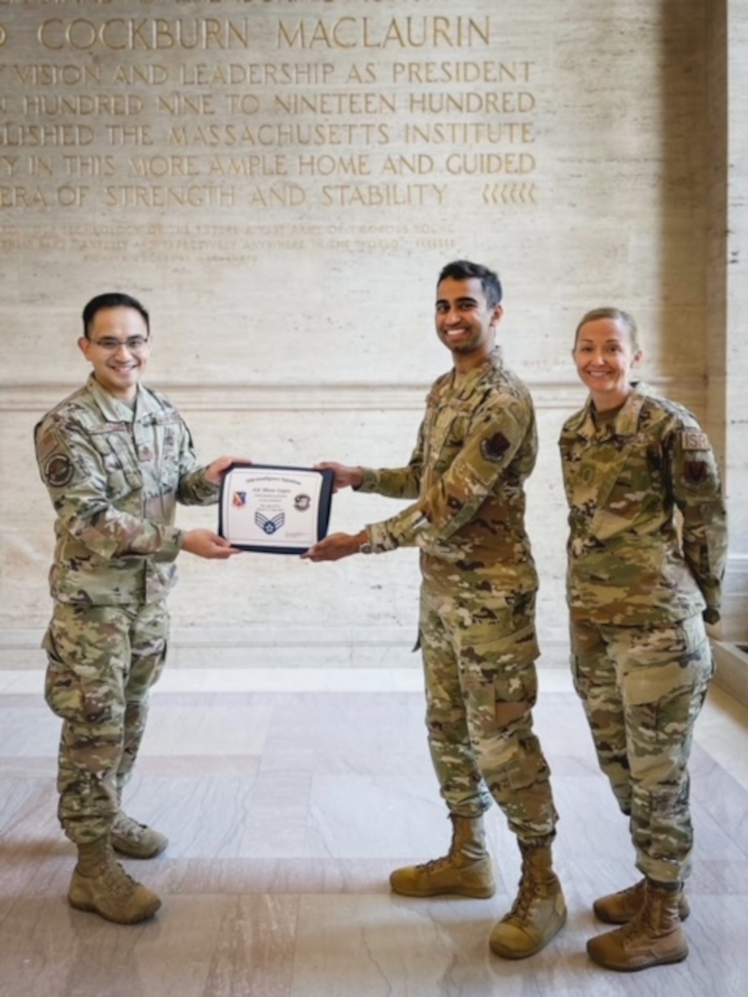 (Left) Maj. Jeremy Santiano and (right) Senior Master Sgt. Amber Isenberg congratulates (center) Airman 1st Class Dhruv Gupta for promoting to Senior Airman during their visit to Massachusetts Institute of Technology, in Cambridge, Mass on May 27. Gupta will be promoting to SrA June 17, 2022. Santiano is the 35th Intelligence Squadron Director of Operations and Isenberg is the 35th IS Operations Superintendent.