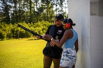 Soldier from Army Marksmanship Unit shows guest a weapon used for skeet shooting.