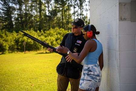 Soldier from Army Marksmanship Unit shows guest a weapon used for skeet shooting.