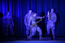 Soldiers in uniform play musical instruments.