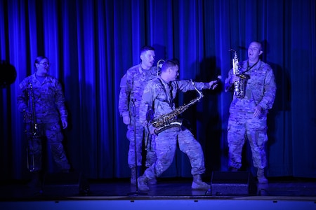 Soldiers in uniform play musical instruments.