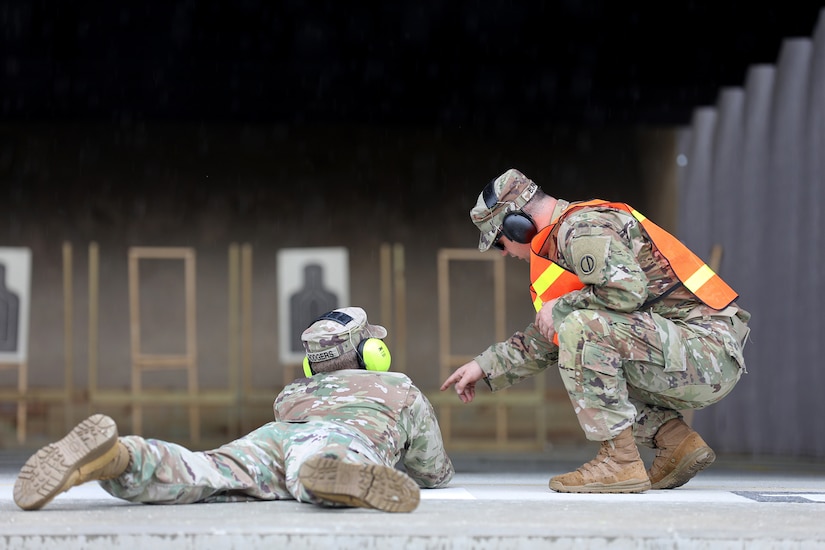 U.S. Army Reserve Sgt. 1st Class Thomas Burke, right, range safety, assists a firer with the M-9 Beretta in the prone position during an individual weapons qualification at the Joliet Training Area, June 8, 2022.