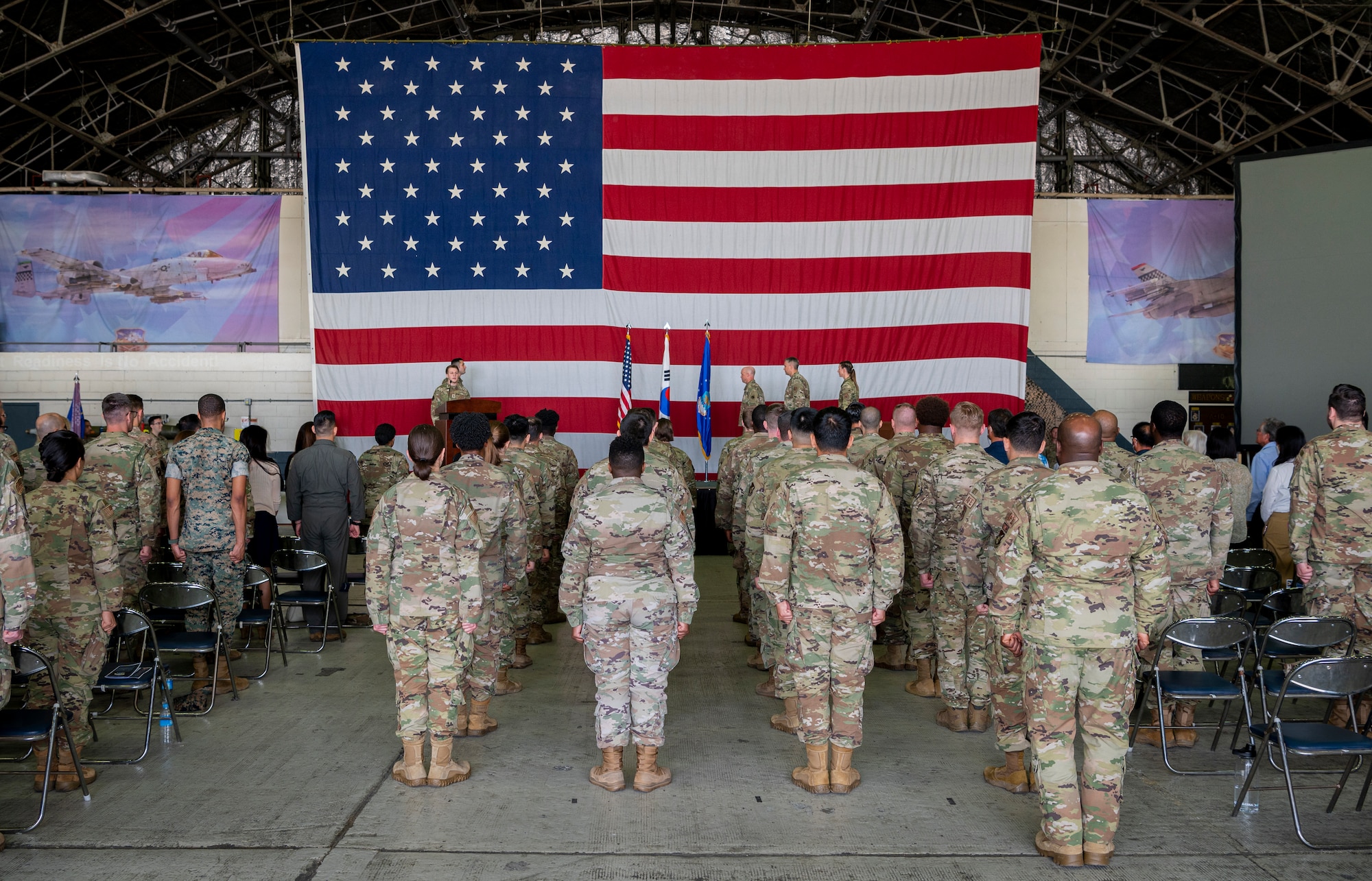 51st Operations Group members stand at attention for the singing of the U.S. National anthem during the 51st Operations Support Squadron Change of Command ceremony at Osan Air Base, Republic of Korea, June 7, 2022.