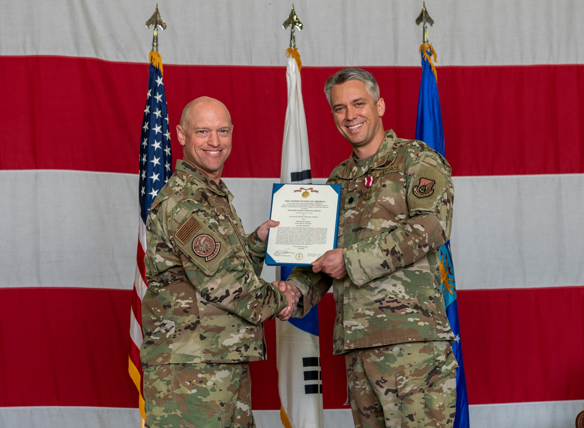 Col. Mathew Gaetke, 51st Operations Group commander, left, presents Lt. Col. William Yoakley, 51st Operations Support Squadron outgoing commander, a Meritorious Service Medal at Osan Air Base, Republic of Korea, June 7, 2022.