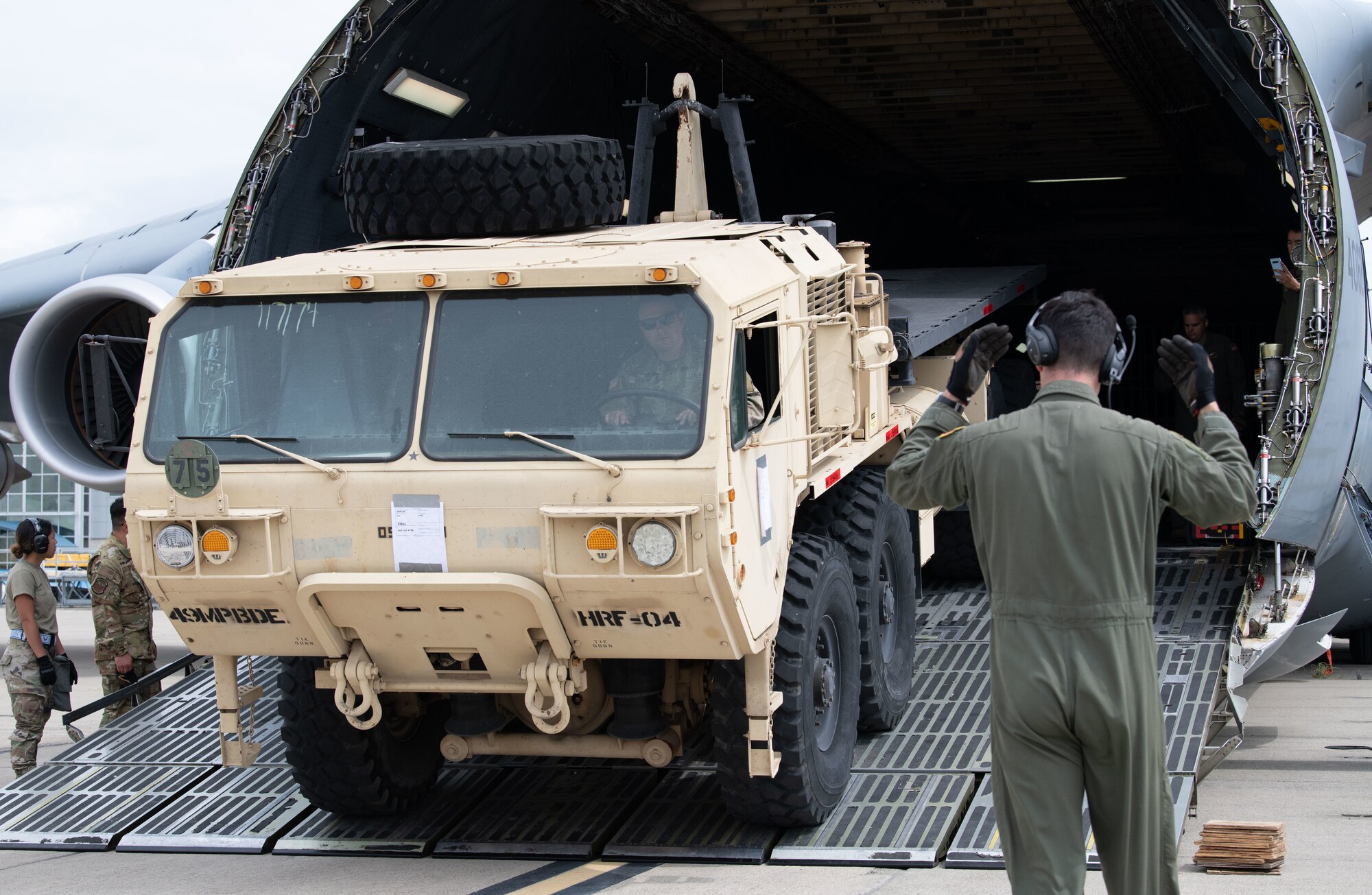 Reserve Citizen Airmen from Soldiers from the California Army Guard's 49th Military Police Brigade, and Airmen from the California Air National Guard's 129th Rescue Wing  offload a M98 Heavy Expanded Mobility Tactical Truck from a C-5M Super Galaxy at Moffett Air National Guard Base, California, June 04, 2022. Nexus Rising is a readiness exercise designed to test the ability of the wing to generate, employ, and sustain air operations in a simulated combat environment. Reserve Citizen Airmen from Travis Air Force Base partnered with California Army and Air National Guard members for the three-day exercise. (U.S. Air Force photo by Staff Sgt. Ryan Green)