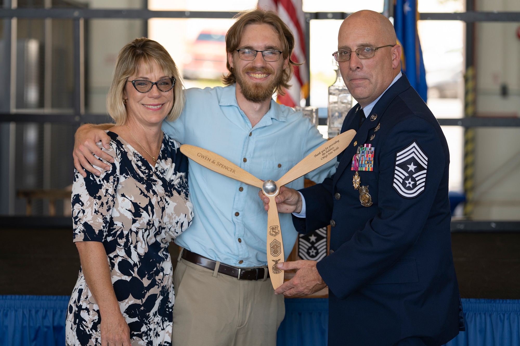 Chief Master Sgt. Webb and his family pose on stage with a gift he received during his retirement ceremony.