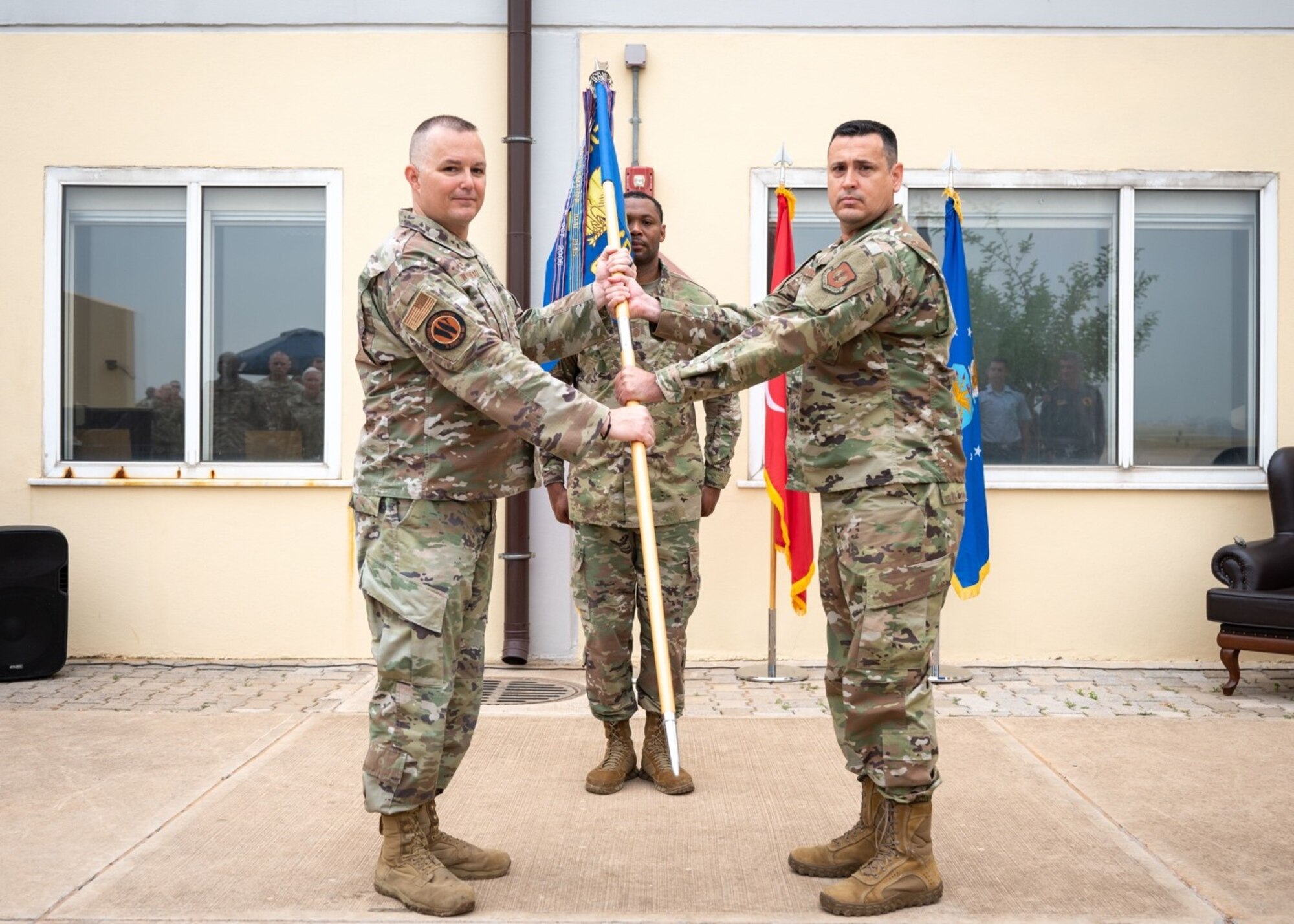 Col. Douglas Whitehead, 39th Weapons Systems Security Group commander, passes the guidon to Lt. Col. Octavio Prieto, incoming 39th Operations Support Squadron commander, during a change of command ceremony at Incirlik Air Base, Turkey, June 3, 2022. During the ceremony, Lt. Col. Christopher Dieter relinquished command to Whitehead, who then charged Prieto with leading the 39th OSS. The change of command ceremony is a long-standing military tradition that represents the formal transfer of command from one officer to another. Prieto previously served as the commander of Headquarters Air Combat Command Air Operations Squadron Detachment 1, Ramstein Air Base, Germany. (U.S. Air Force photo by Staff Sgt. Gabrielle Winn)