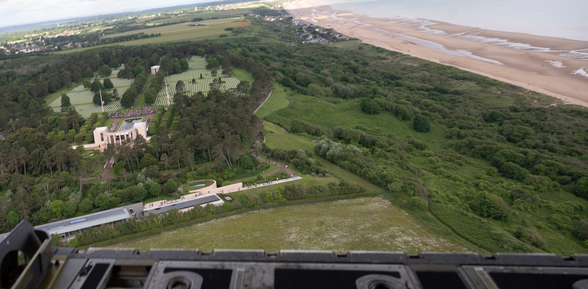 A C-130J Super Hercules aircraft assigned to the 86th Airlift Wing, Ramstein Air Base, Germany, flies over  a D-Day ceremony at the Normandy American Cemetery, Normandy, France, June 6, 2022. The Normandy American Cemetery is where 9,886 American service members are buried who were killed during the Normandy Landing on June 6, 1944, as they stormed the beaches of Normandy and began the liberation of Western Europe. (U.S. Air For photo by Senior Airman Thomas Karol)