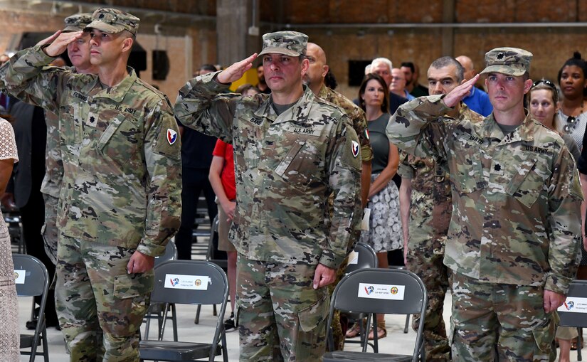 Outgoing Army Field Support Battalion-Africa Commander Lt. Col. Miguel Flores, 405th Army Field Support Brigade Commander Col. Brad Bane and incoming AFSBn-Africa Commander Lt. Col. Alexander Amato render honors to the National Colors at the AFSBn-Africa change of command ceremony June 10 at Leghorn Army Depot, Italy (photo by Vincenzo Vitiello)