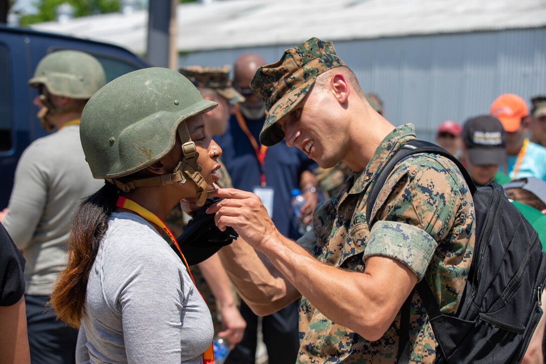 Yordanos Beyene, a Brand Apostles agency representative, receives help from a Marine on how to wear her kevlar helmet on in preparation for the Leadership Reaction Course during the Marine Corps Recruiting Command’s Educators' Workshop at the Officer Candidate School at Marine Corps Base Quantico, Va., June 8. The workshop provides Traditional 4-year college/university and Junior\Community college educators and administrators, from priority colleges and universities, the opportunity to learn how Marines officers are recruited, trained and developed into leaders from a pool of highly qualified college students. Upon successful execution of the workshop, attendees will return to their schools and communities better equipped to tell the Marine Corps story and become cornerstone advocates. (U.S. Marine Corps Lance Cpl. Jennifer Sanchez)