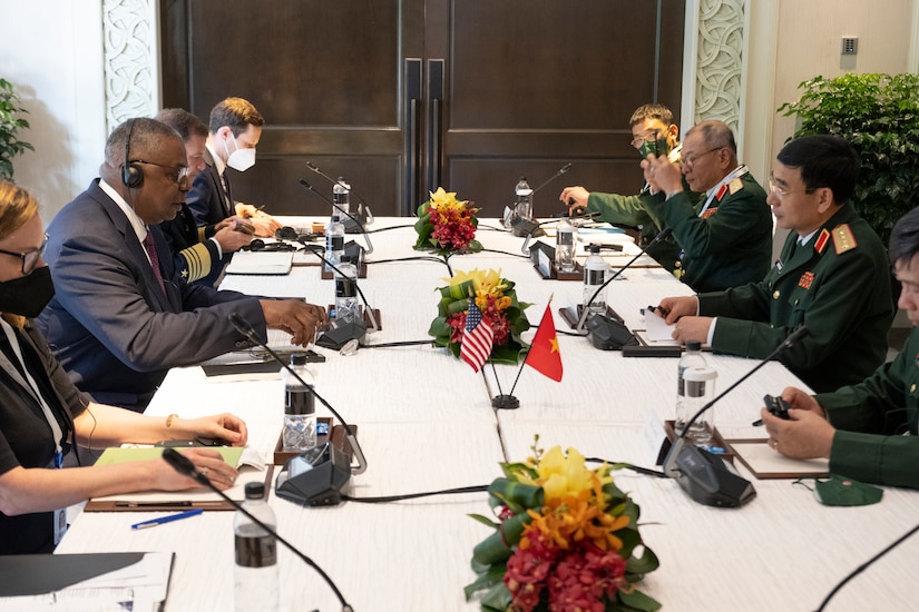 A group of people sit around a long table.