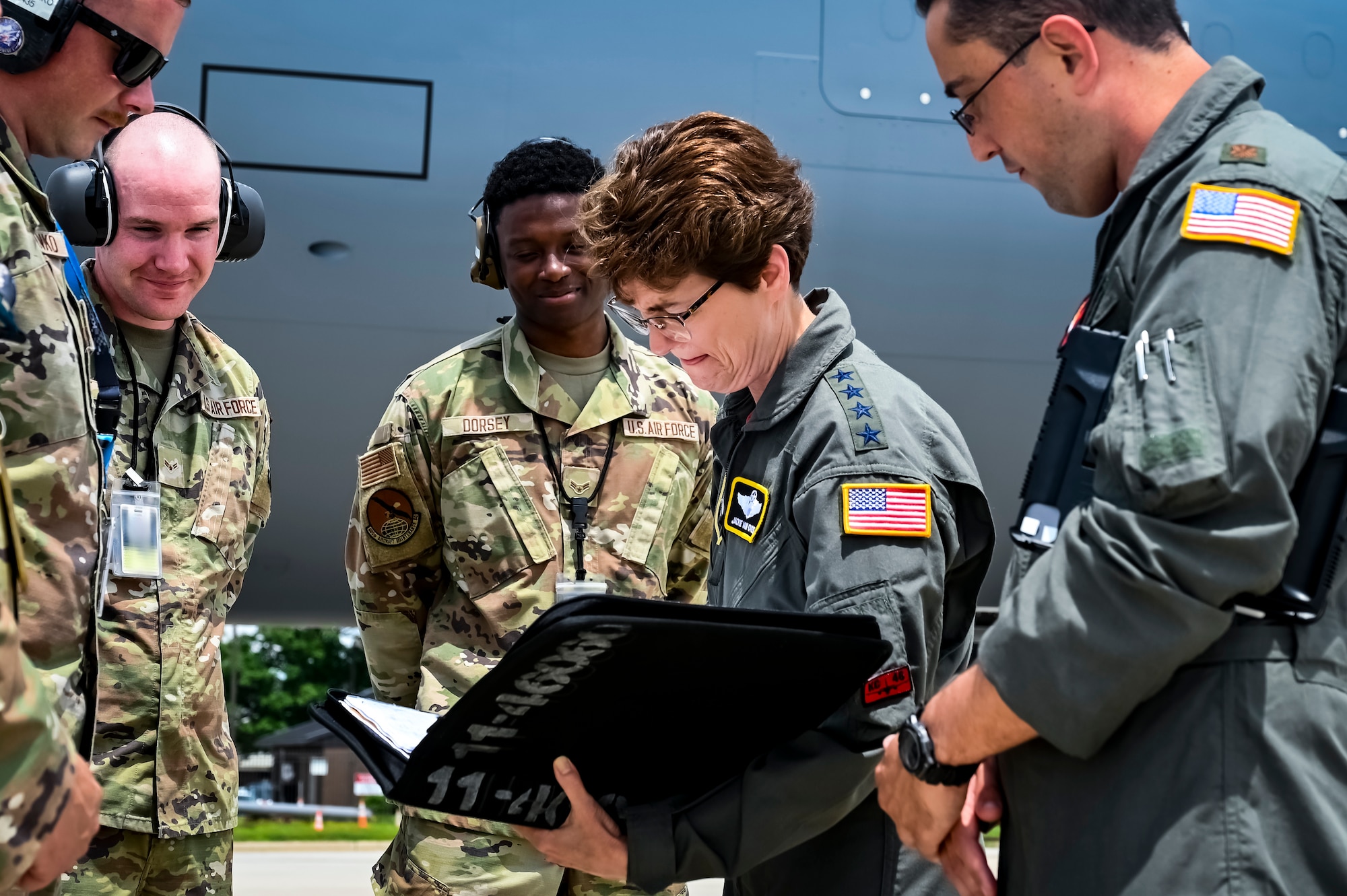 U.S. Air Force Gen. Jacqueline Van Ovost, U.S. Transportation Command commander, and U.S. Air Force Maj. Gen. Mark Camerer, U.S. Air Force Expeditionary Center commander, view a mural in memory of Operation Allies Welcome at Joint Base McGuire-Dix-Lakehurst, New Jersey, June 3, 2022. Van Ovost toured the center, coined Airmen for their services during OAW, and addressed recent graduates of the Advanced Study of Air Mobility course.