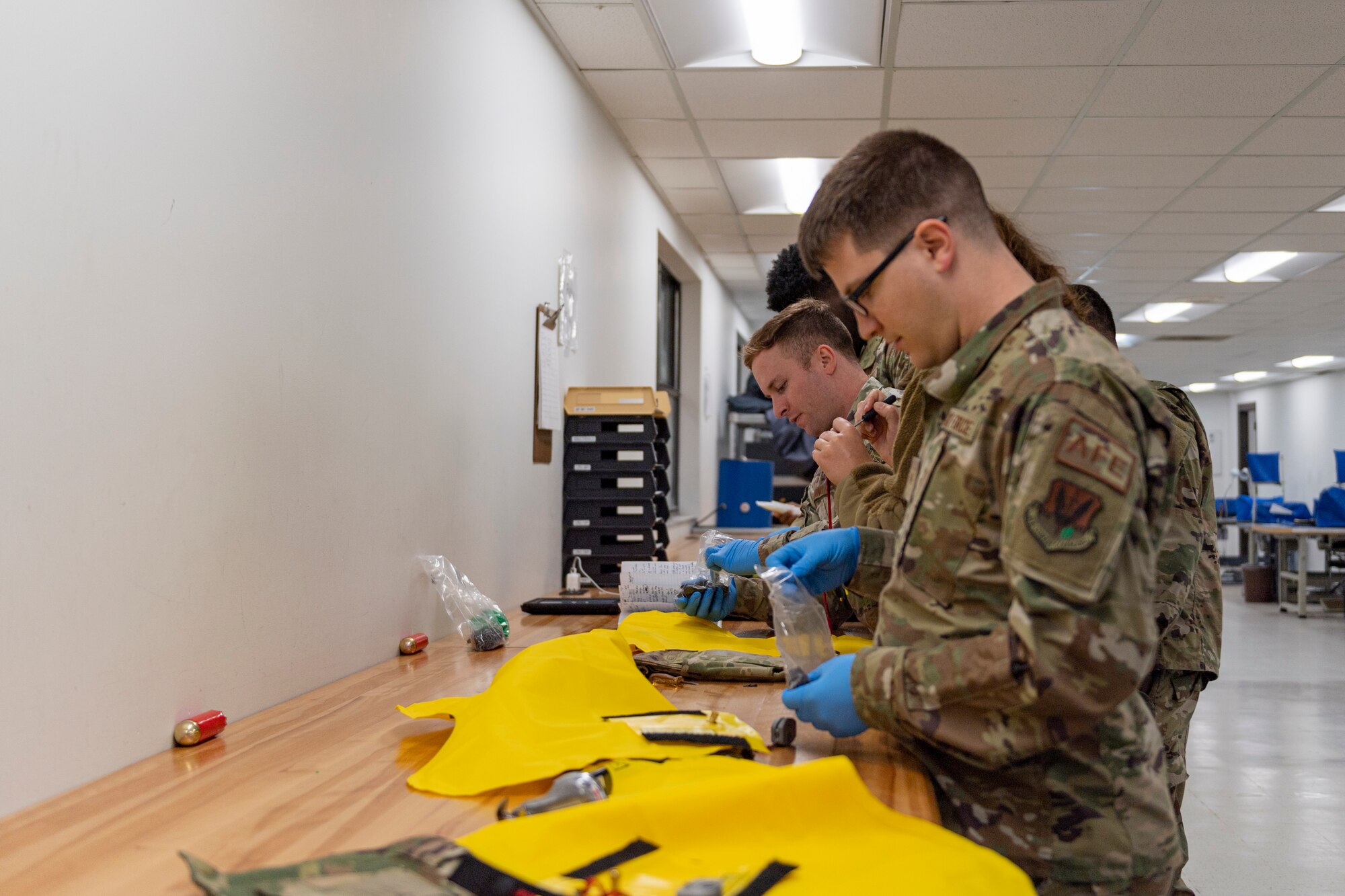 Photo of an Airman performing maintenance on a combat tactical aid flotation