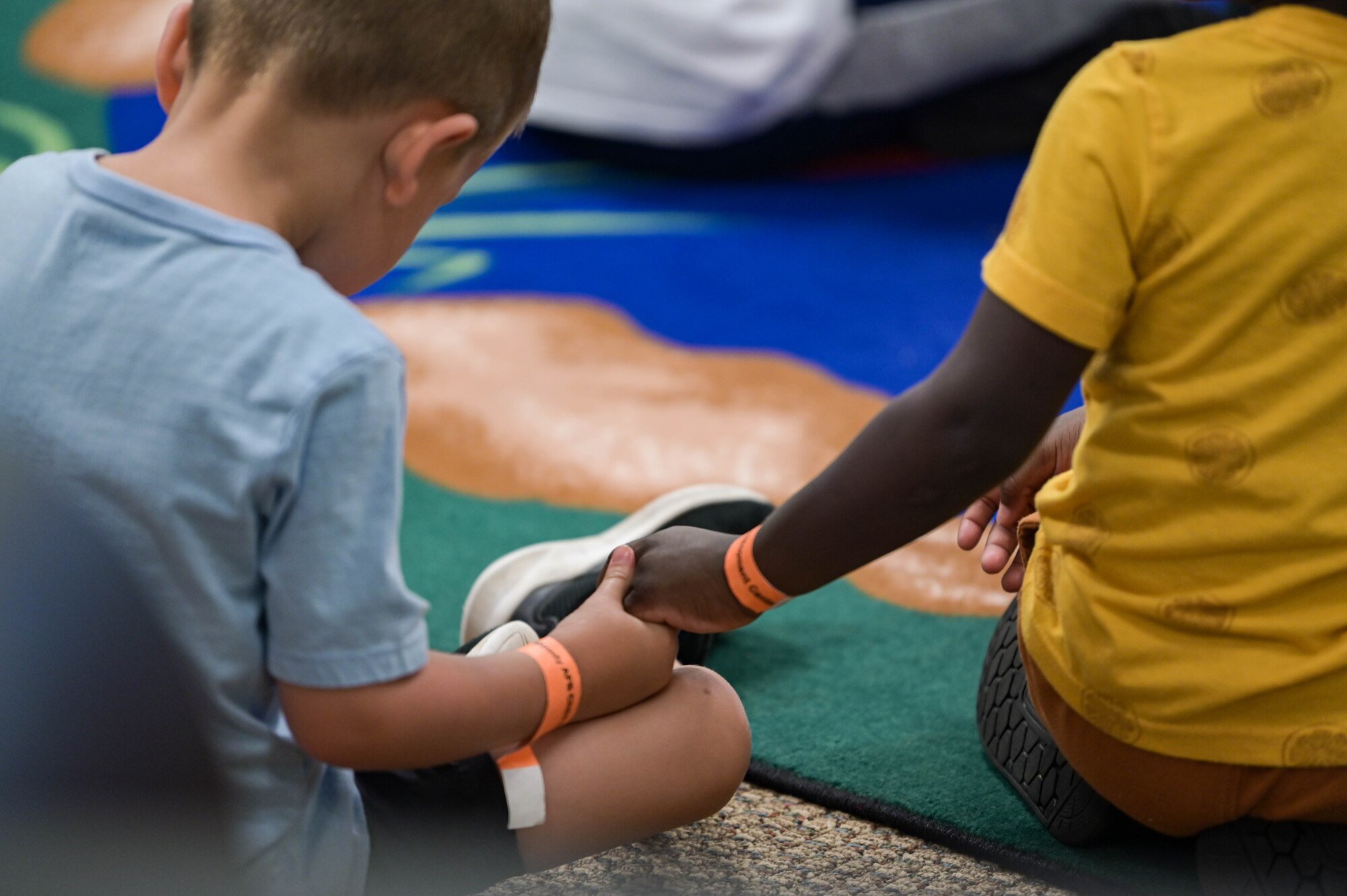 Two children from the Child Development Center hold hands at Moody Air Force Base, Georgia, June 7, 2022. The Valdosta Rotary Club partners with Dolly Parton’s Imagination Library to provide monthly books to children under the age of 5-years-old. (U.S. Air Force photo by Senior Airman Rebeckah Medeiros)