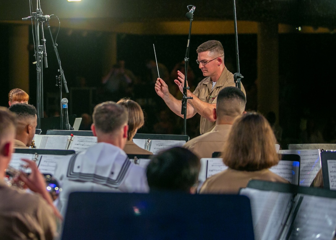 U.S. Marine Corps Chief Warrant Officer 2 Stephen J. Talbot, officer in-charge, U.S. Marine Corps Forces, Pacific (MARFORPAC) Band, conducts the band’s rendition of “Each Time You Tell Their Story” during “An Evening with the Marines,” a concert at the Hale Koa Hotel, Honolulu, March 25, 2022. During the event, Marines and sailors of The United States Marine Corps Band collaborated with the MARFORPAC Band to perform for the active duty service members, veterans, and civilians in attendance. (U.S. Marine Corps photo by Cpl. Maximilian C. Campbell)