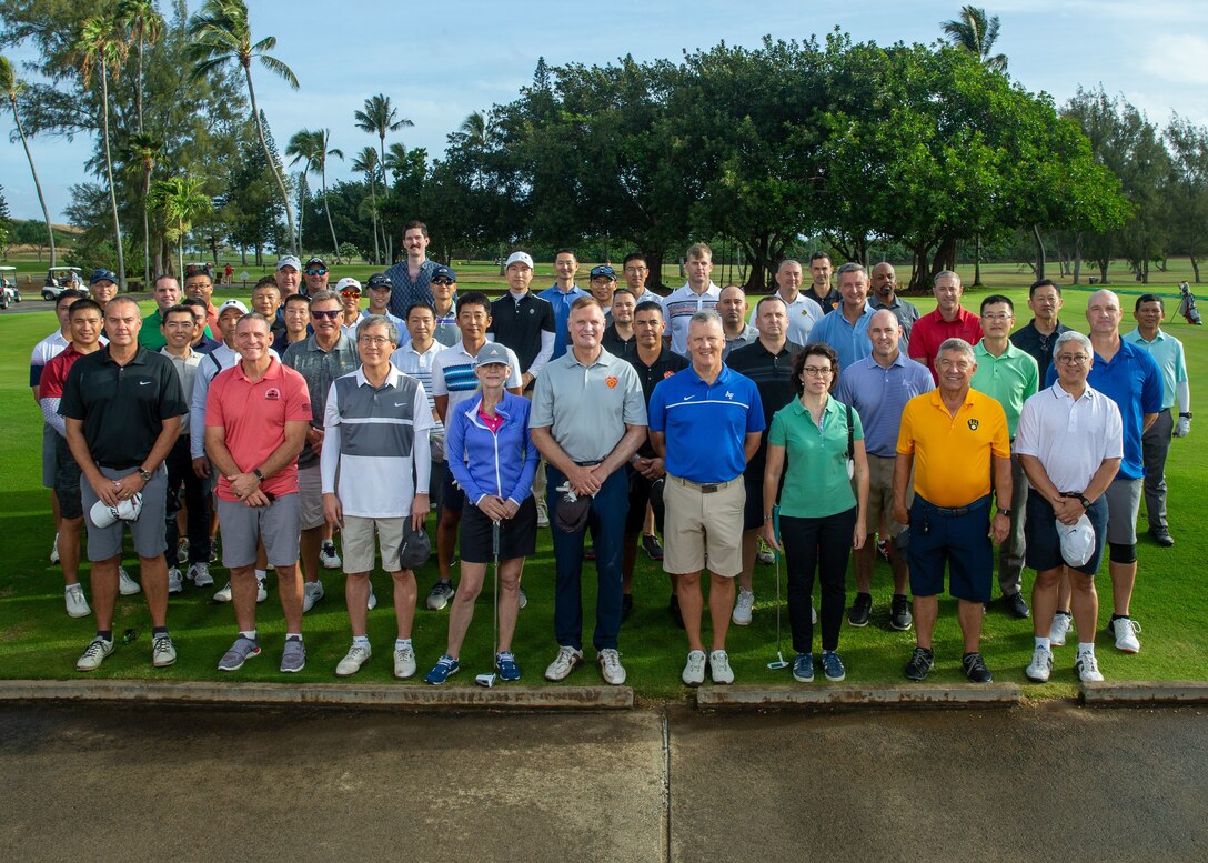 U.S. service members, foreign service members, and civilians with U.S. Marine Corps Forces, Pacific (MARFORPAC) and U.S. Pacific Air Forces (PACAF) and various consulates general- pose for a group photo during the first golf tournament co-hosted between MARFORPAC and PACAF at the Kaneohe Klipper Golf Course, Marine Corps Base Hawaii, May 6, 2022. The tournament focused on camaraderie and international fellowship to strengthen alliances and partnerships in the Indo-Pacific. Representatives of six allies and partners -participated in the event alongside U.S. service members. (U.S. Marine Corps photo by Lance Cpl. Haley Fourmet Gustavsen/ Cpl. Arianna Lindheimer)