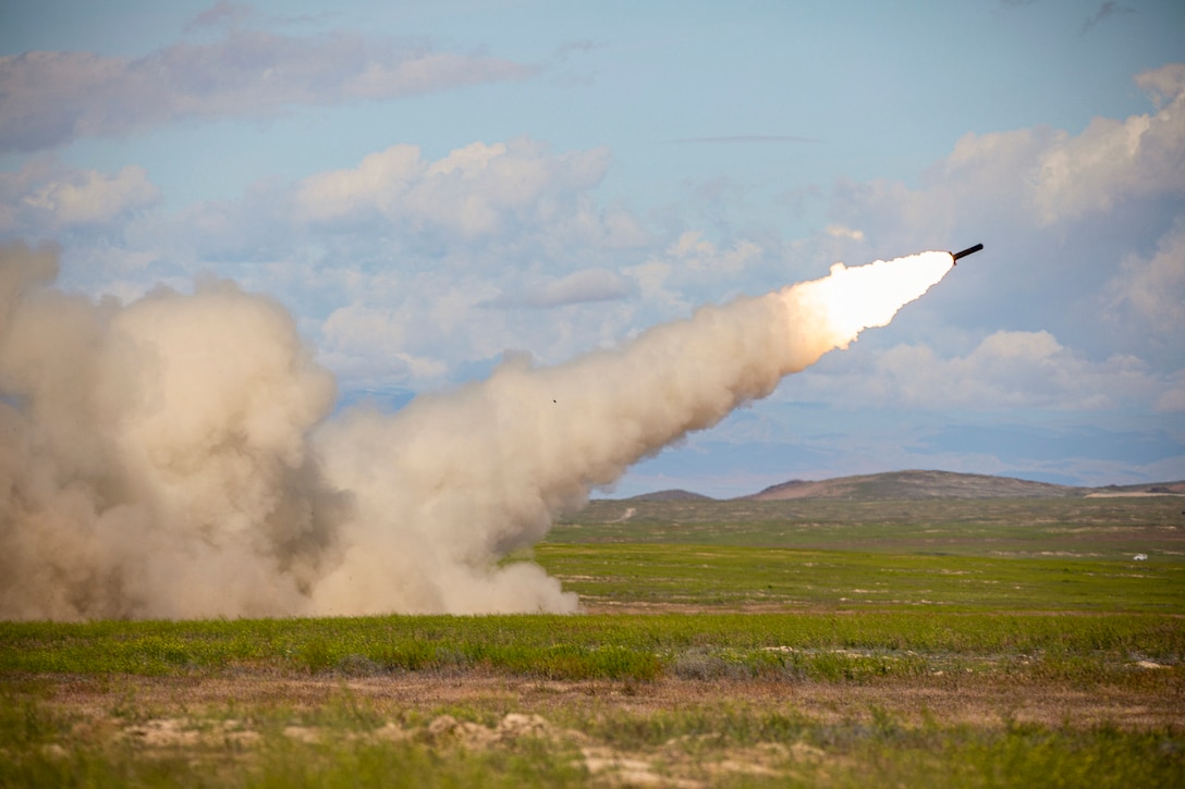 A rocket launches in a field.