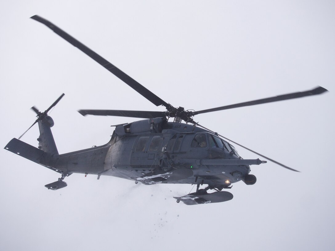 An Alaska Air National Guard 210th Rescue Squadron HH-60G Pave Hawk transits Joint Base Elmendorf-Richardson's Malamute Drop Zone Feb. 10, 2021, during parachute jump operations. The jump presaged the change-of-command ceremony for 212th Rescue Squadron. (U.S. Air National Guard photo by David Bedard)