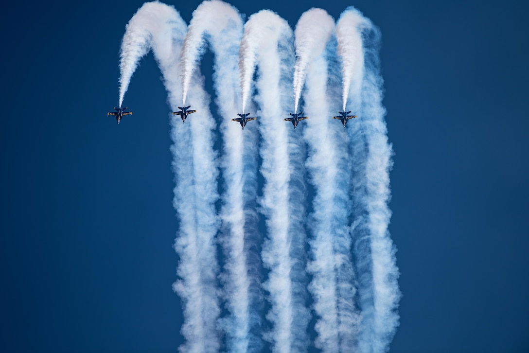 Five aircrafts perform together releasing heavy contrails.